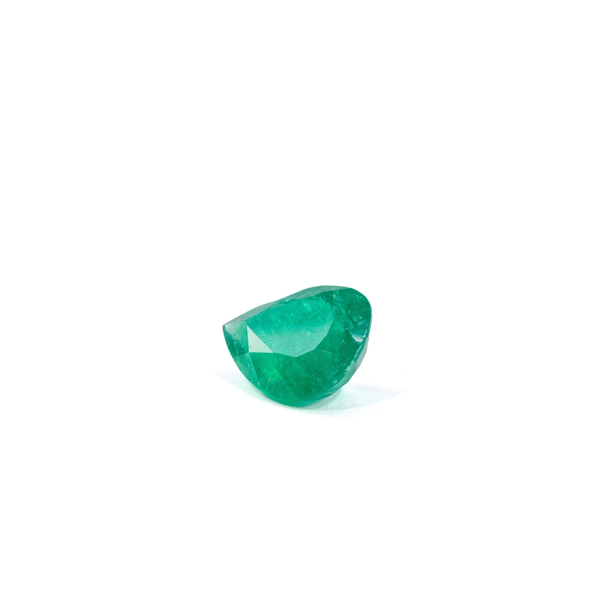 Angled view of pear-cut Colombian Emerald showing internal inclusions
