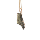 Side view of raw Moldavite crystal pendant with 14K gold prong setting