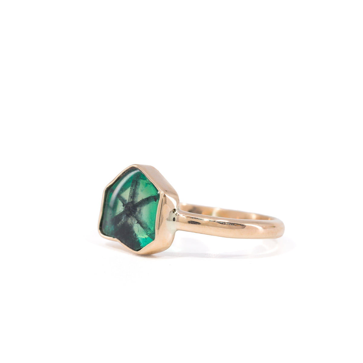 Angled view of handcrafted Trapiche Emerald ring and smooth bezel