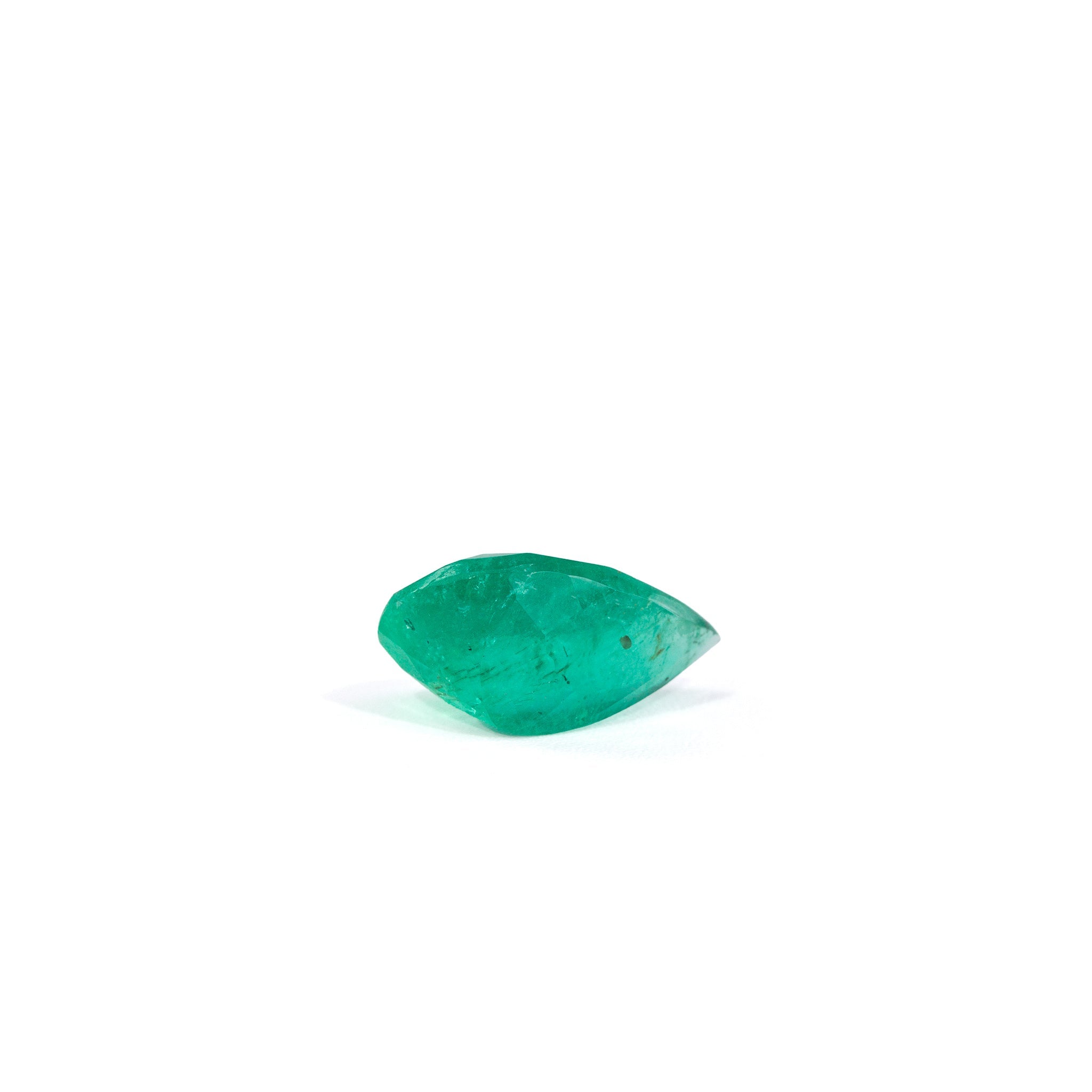Side view of faceted Colombian Emerald showing its curved profile and clarity