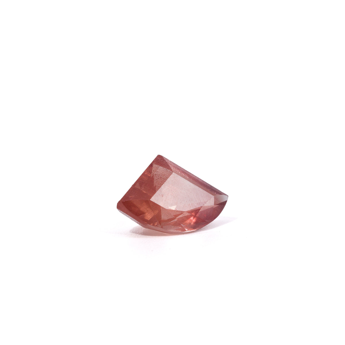 Asymmetrical faceted Oregon Sunstone gemstone with salmon and copper color